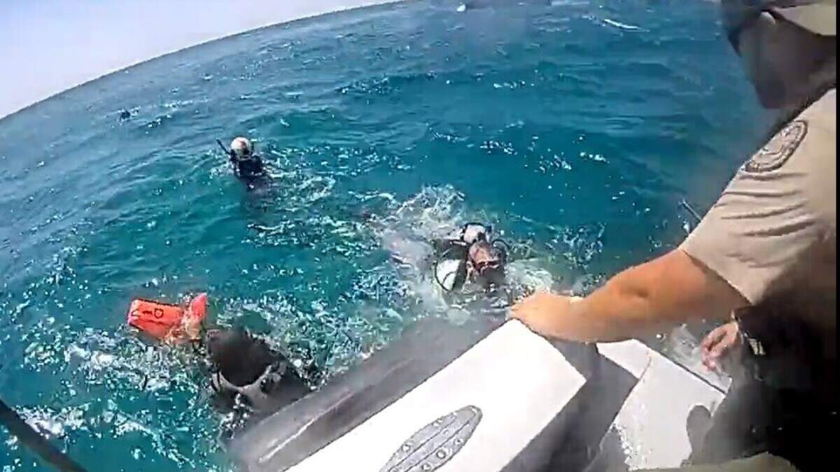 A Florida Fish and Wildlife Conservation Commission officer helps three divers out of the water on Wednesday, July 29, 2026. The men went missing while fishing for spiny lobster on the first day of the two-day lobster miniseason. A Florida Fish and Wildlife Conservation Commission officer helps three divers out of the water on Wednesday, July 29, 2026. The men went missing while fishing for spiny lobster on the first day of the two-day lobster miniseason.